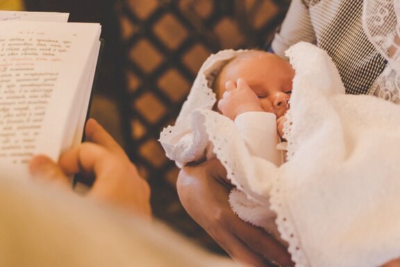 The sacrament of the baptism of a child. Selective focus. People.https://stock.adobe.com/at/search/free?filters%5Bcontent_type%3Aphoto%5D=1&filters%5Bcontent_type%3Aillustration%5D=1&filters%5Bcontent_type%3Azip_vector%5D=1&filters%5Bcontent_type%3